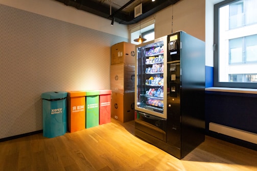black and blue vending machine beside brown wooden cabinet