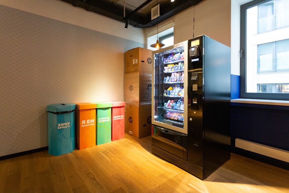 black and blue vending machine beside brown wooden cabinet