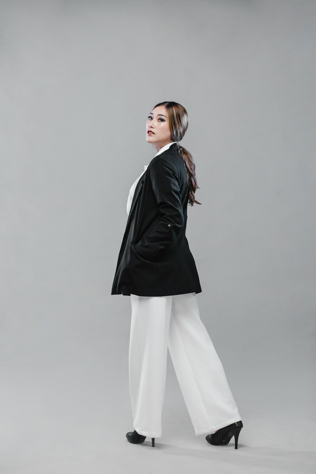 woman in black leather jacket and white pants
