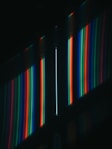 a dark room with a wall of multicolored lights