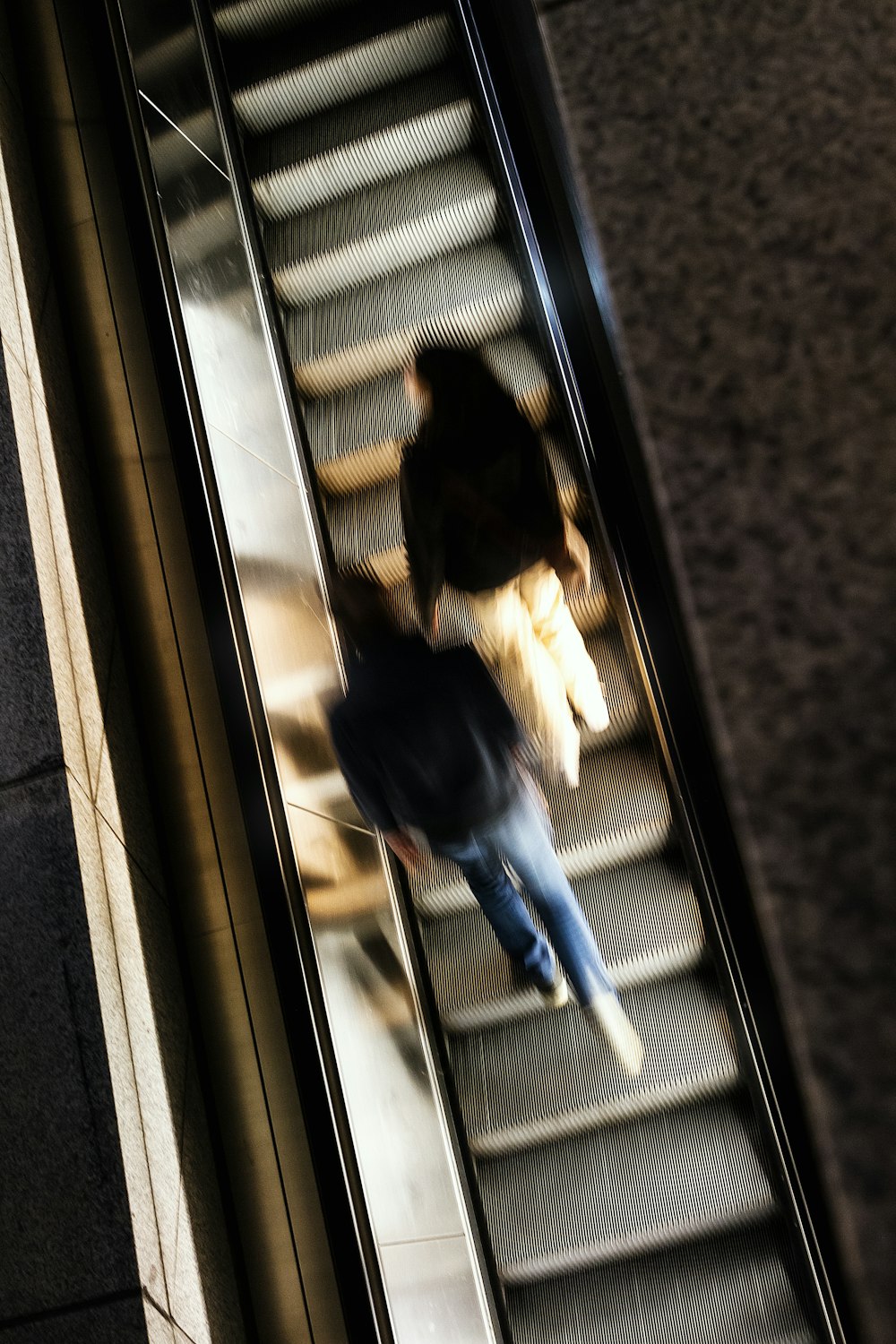 person in blue denim jeans standing beside glass window