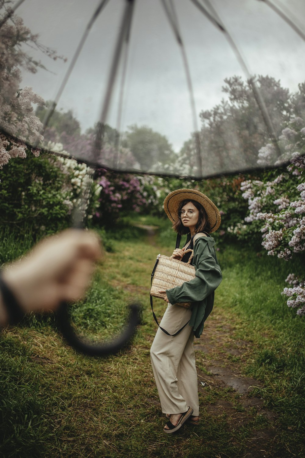 woman in black jacket and brown sun hat standing on green grass field during daytime