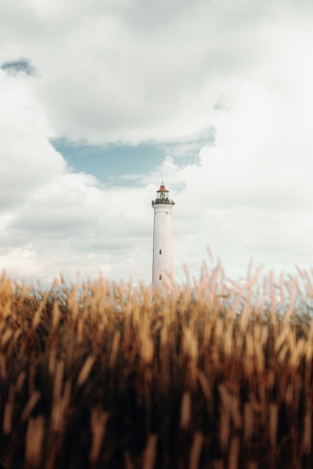 white and brown lighthouse under cloudy sky during daytime