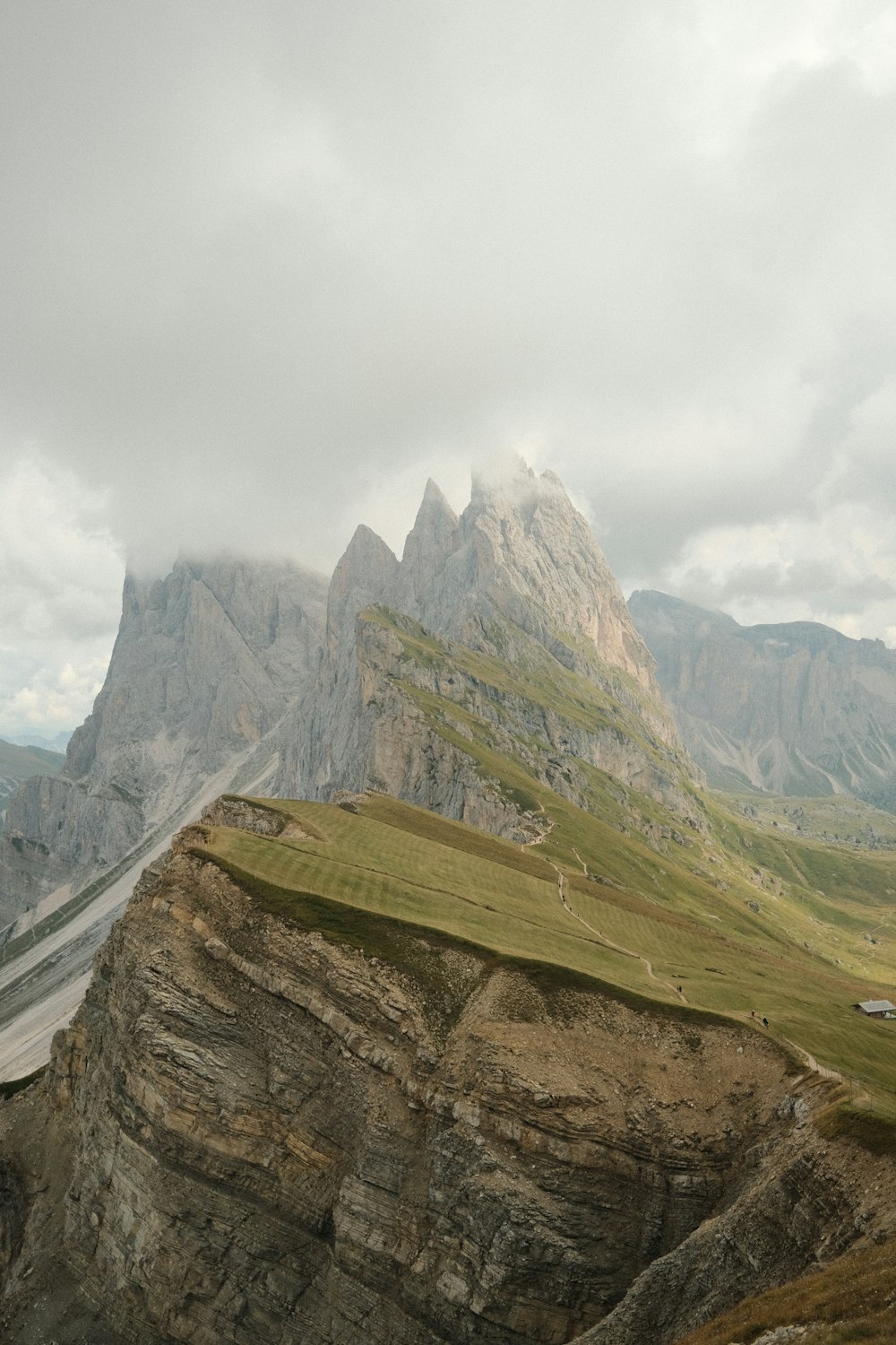 montagne verdi e marroni sotto il cielo nuvoloso bianco durante il giorno