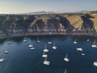 white boats on sea near brown mountain during daytime