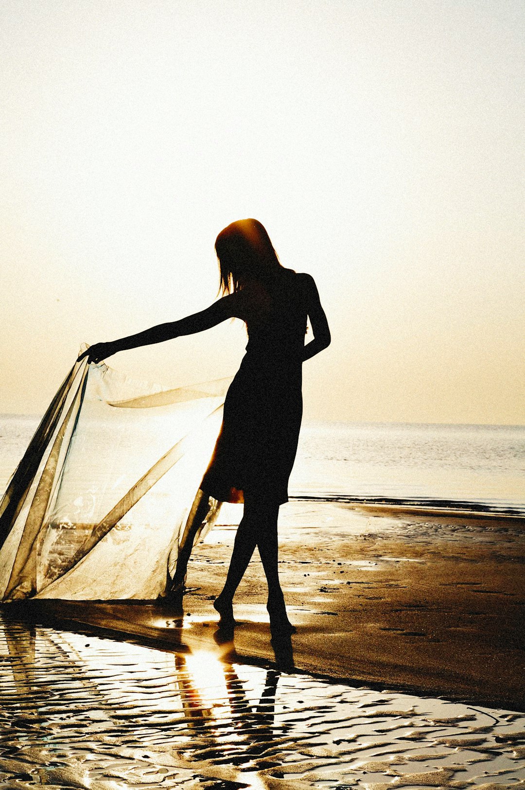 woman in black dress standing on beach during daytime