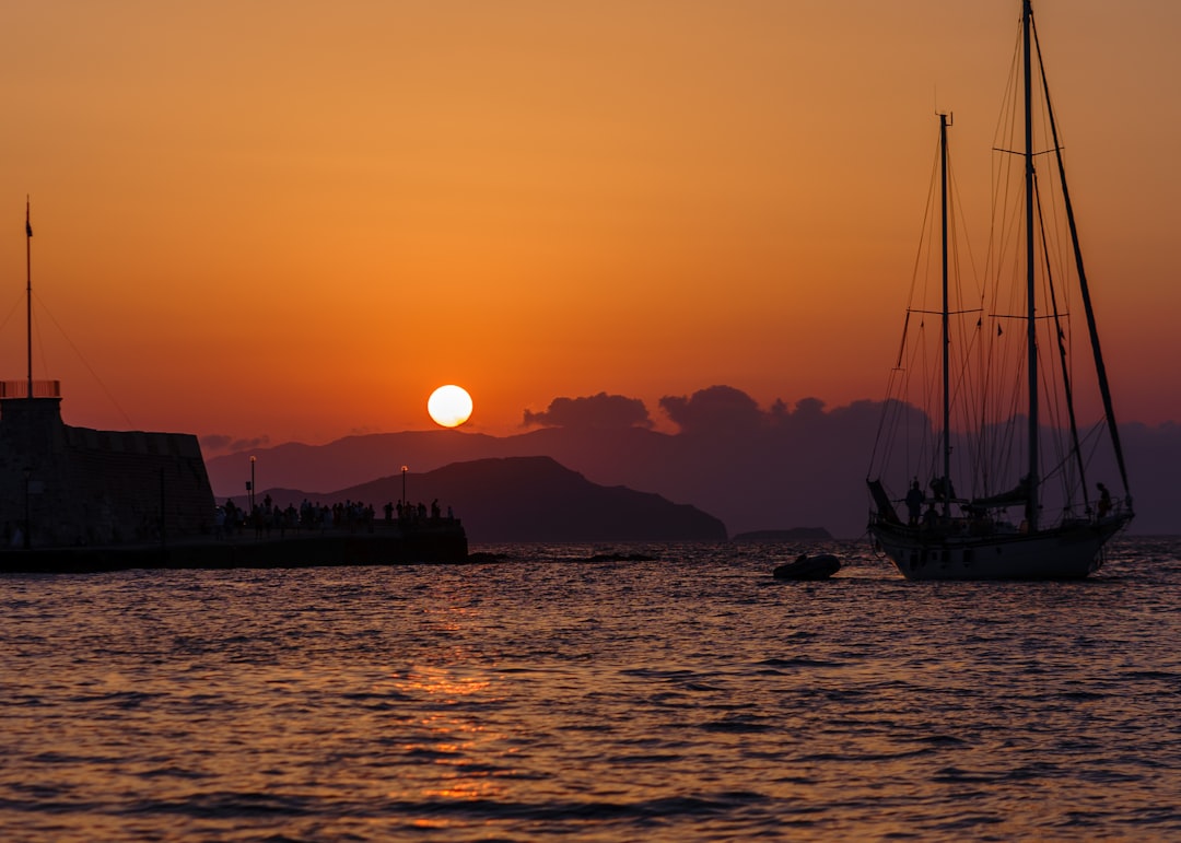 silhouette of boat on sea during sunset
