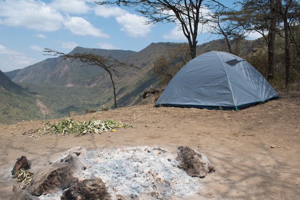 gray tent on brown sand near mountains during daytime