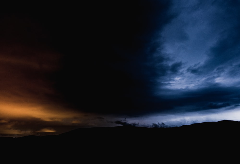 silhouette of mountain under blue sky during night time