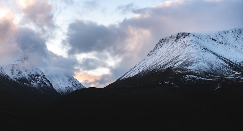 black and white mountain under white clouds