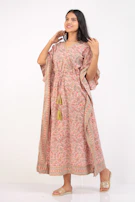 Flowy bohemian dress with intricate patterns displayed on a rustic chair.