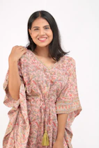 A joyful customer wearing a custom sublimation tee with boho patterns in warm pinks.