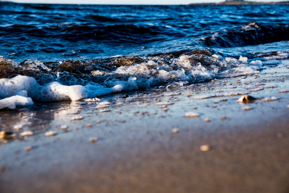 ondas de água na areia marrom durante o dia