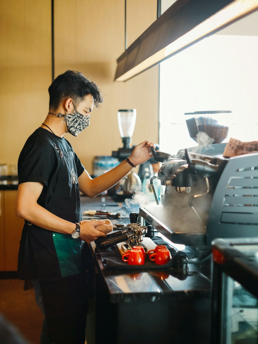 man in blue t-shirt holding stainless steel kettle