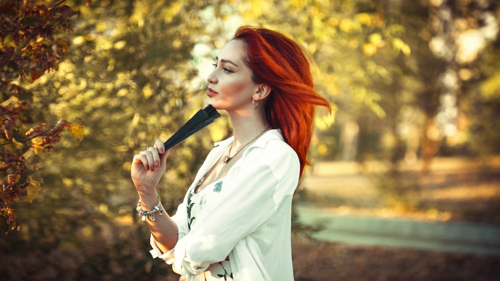 woman in white long sleeve shirt holding black microphone