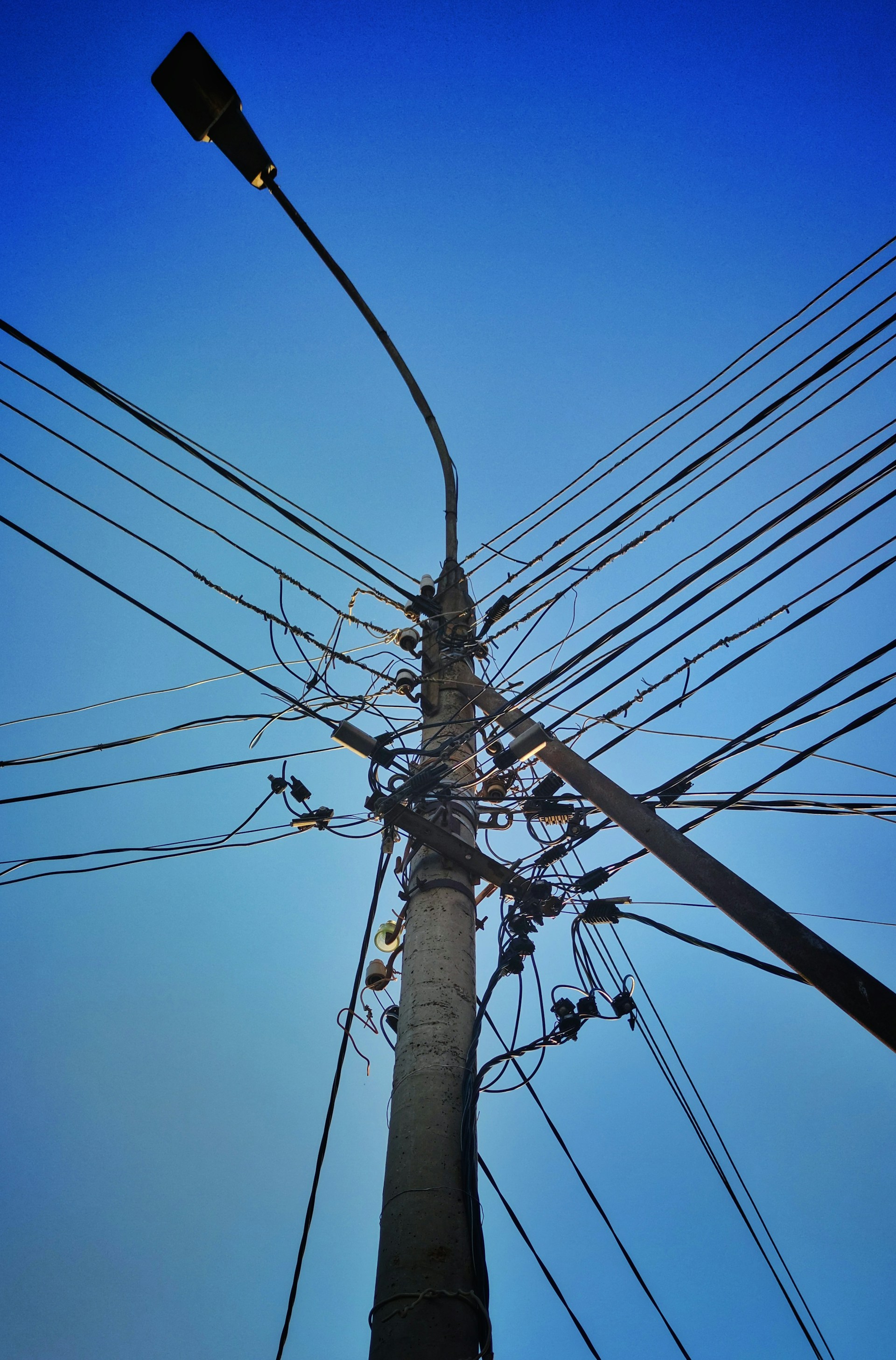 black electric post under blue sky during daytime