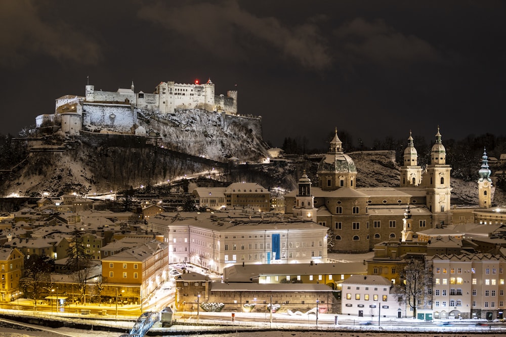 white and brown concrete building near mountain during night time