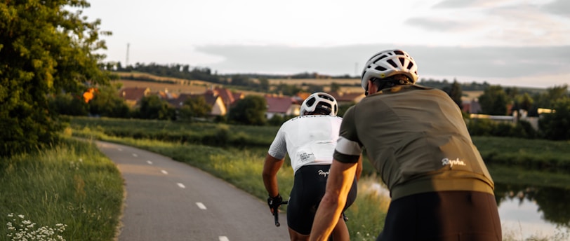 man in brown t-shirt riding on bicycle on road during daytime