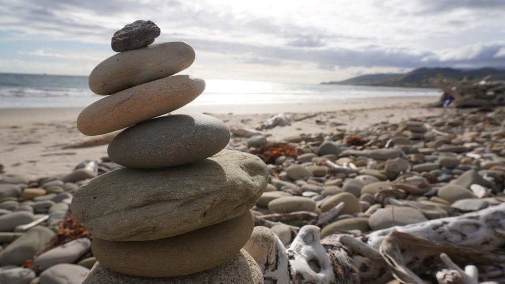 Pila de piedra marrón y gris en la orilla de la playa durante el día
