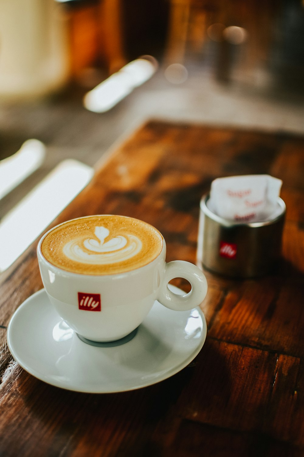 white ceramic cup with saucer on brown wooden table