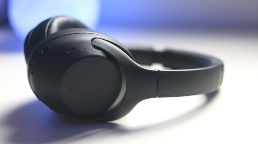 black and gray headphones on blue textile