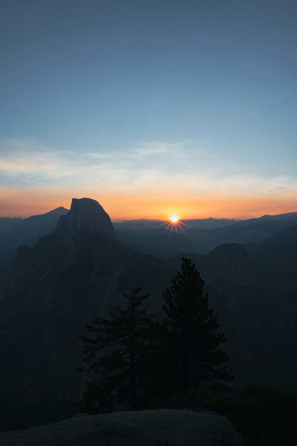 silhouette of trees and mountains during sunset