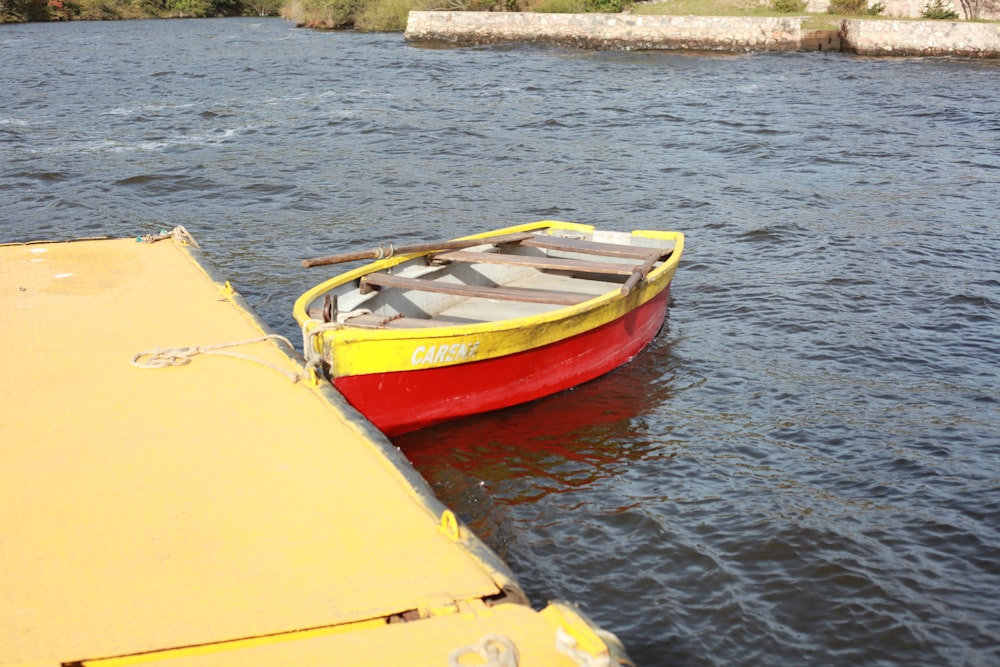 yellow and red boat on water during daytime