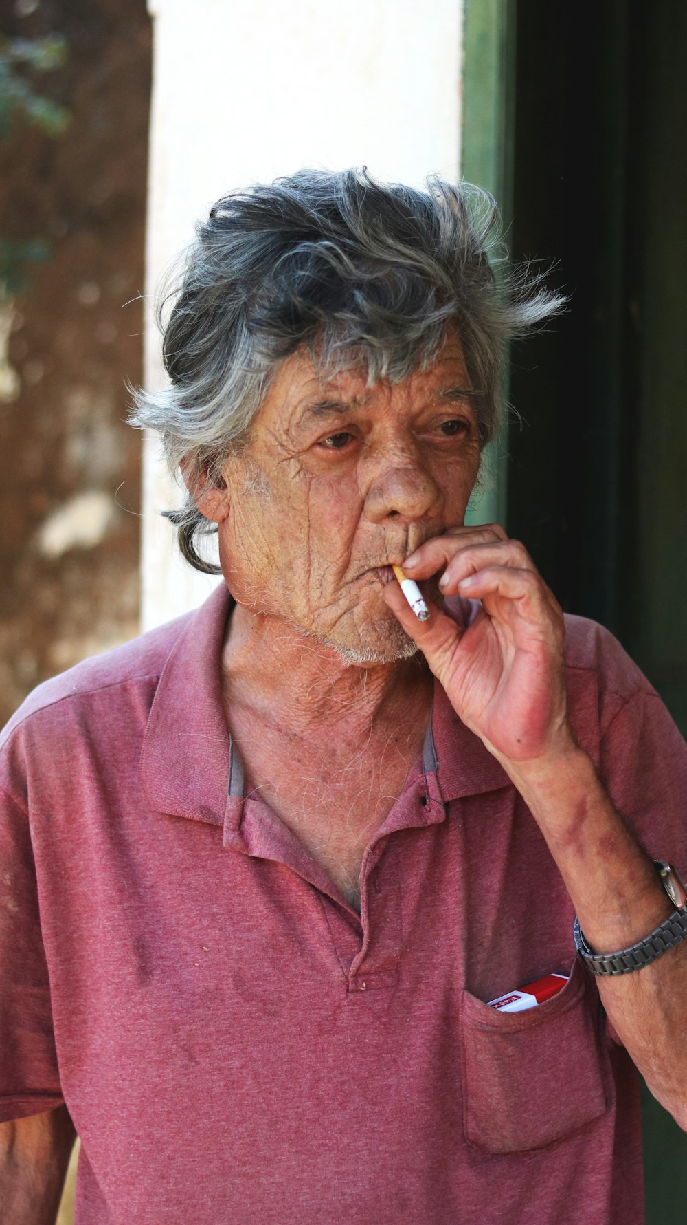 woman in pink button up shirt smoking