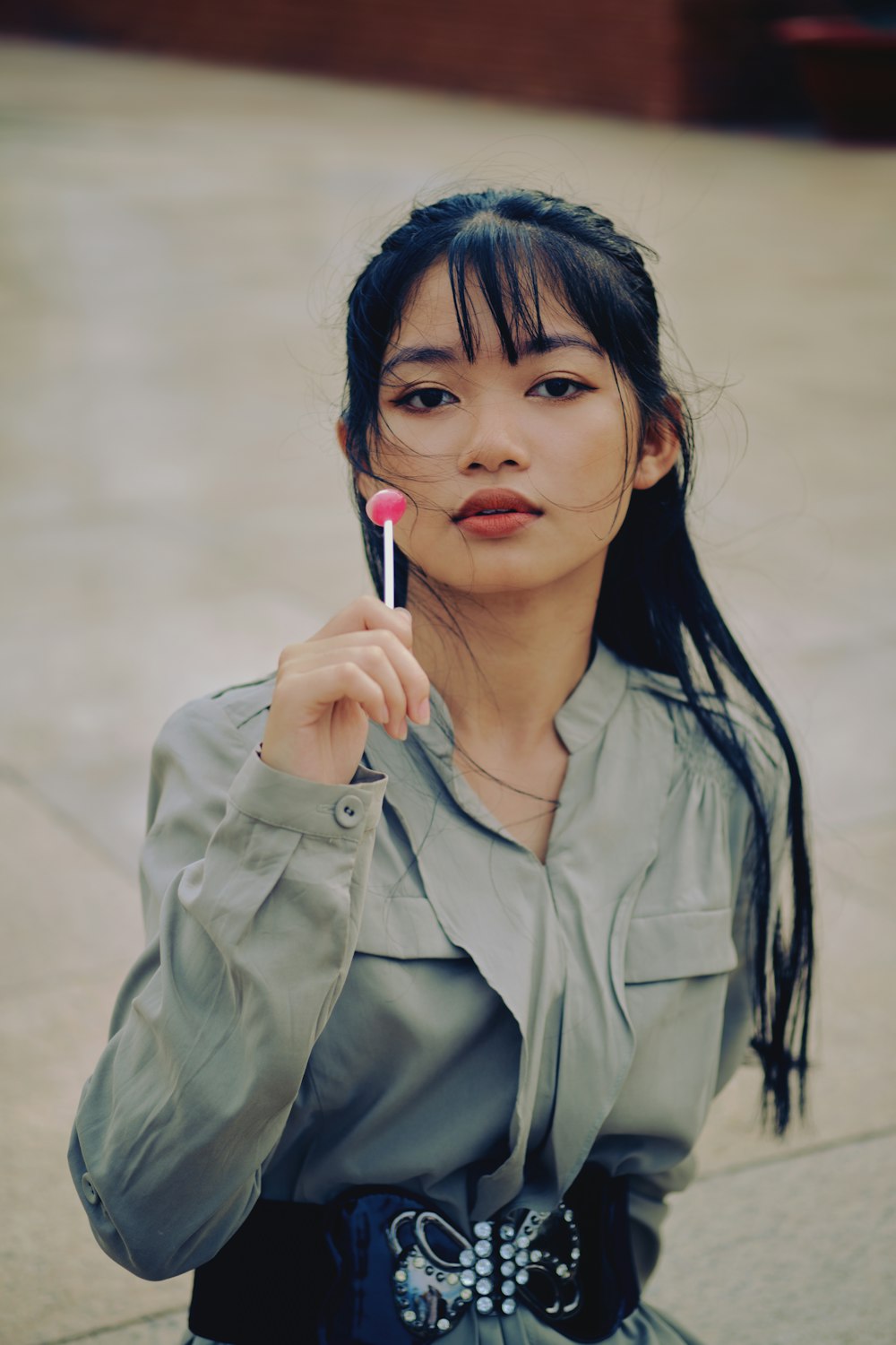 woman in gray button up shirt holding red pen