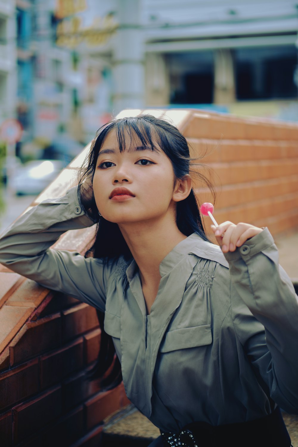 girl in gray jacket holding red plastic cup