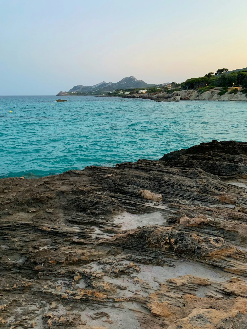 brown rock formation near body of water during daytime