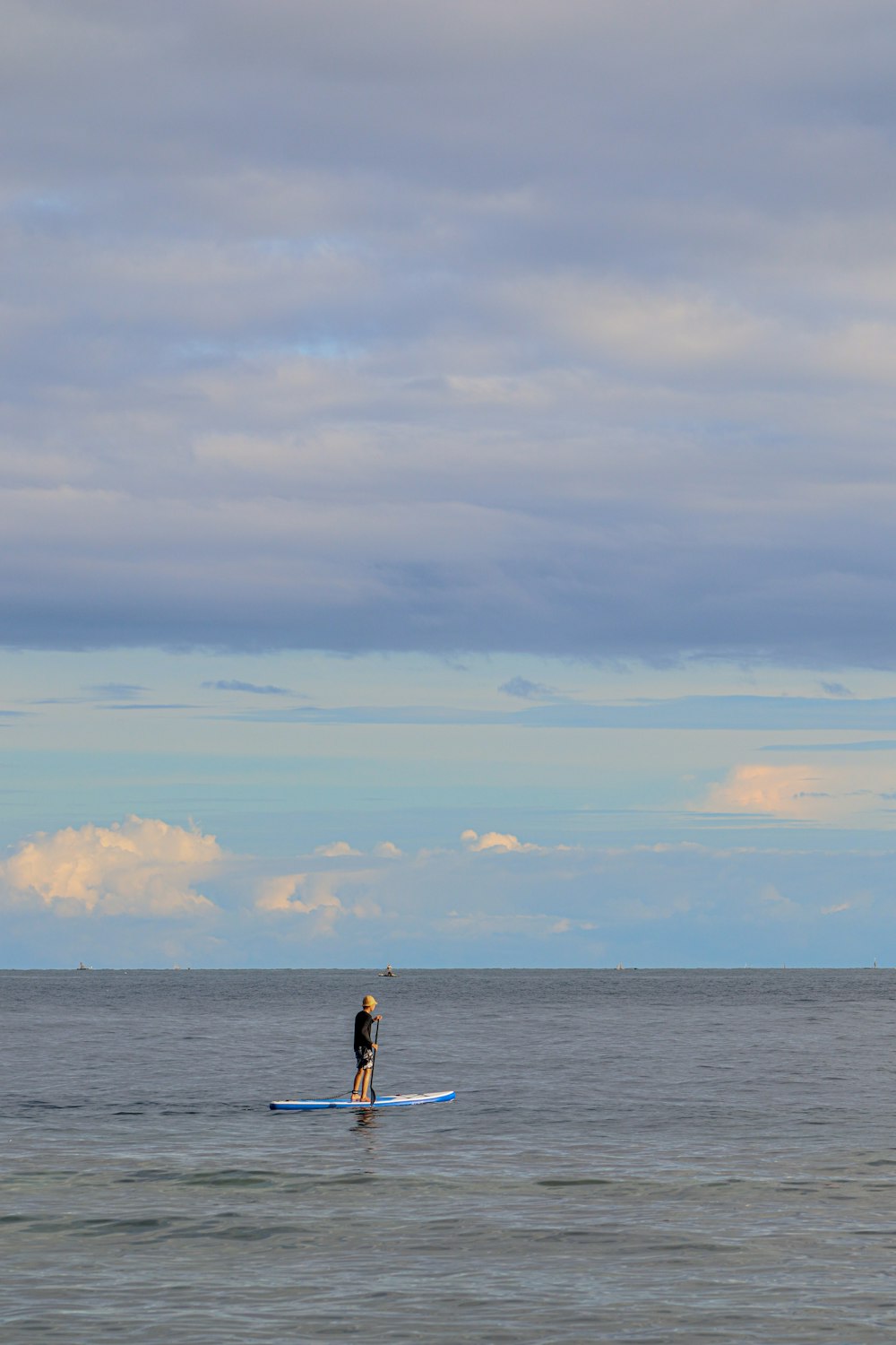 homme en short noir debout sur le bord de la mer pendant la journée