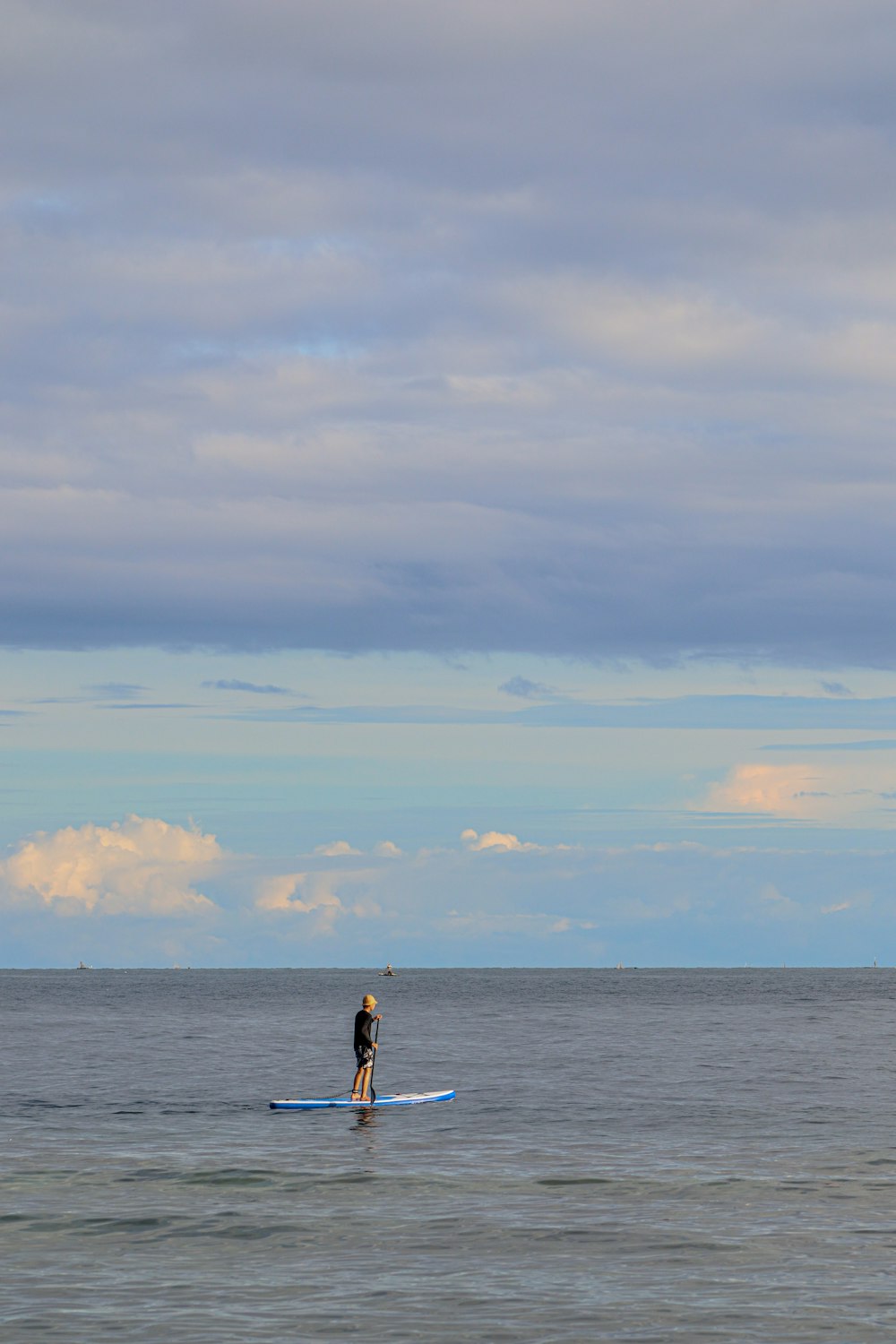 man in black shorts standing on sea shore during daytime