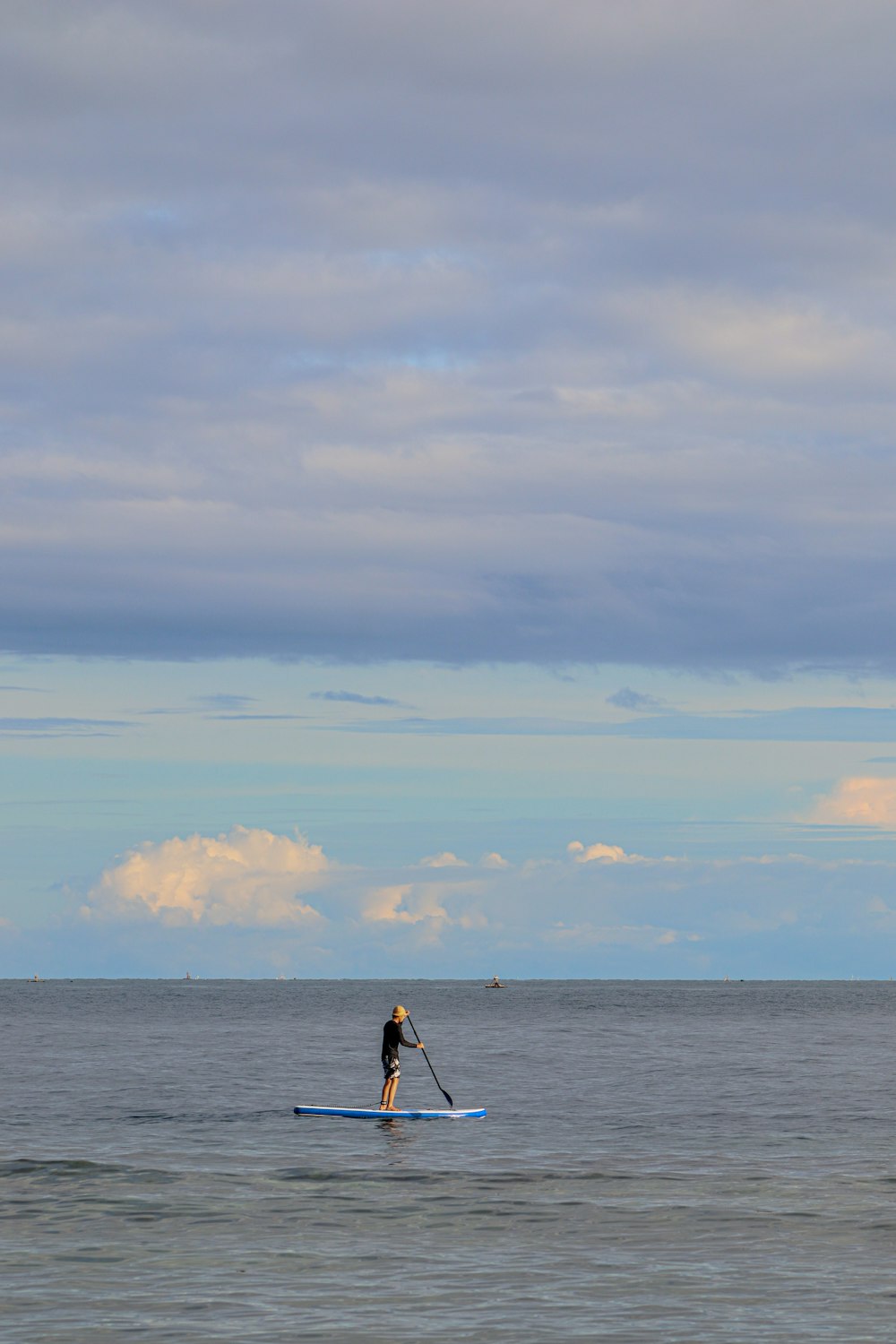 man in black shirt and black shorts standing on sea shore during daytime