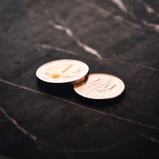 2 silver round coins on black textile