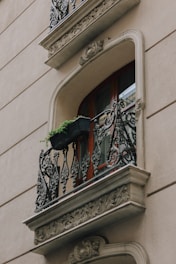 black metal window grill on white concrete building