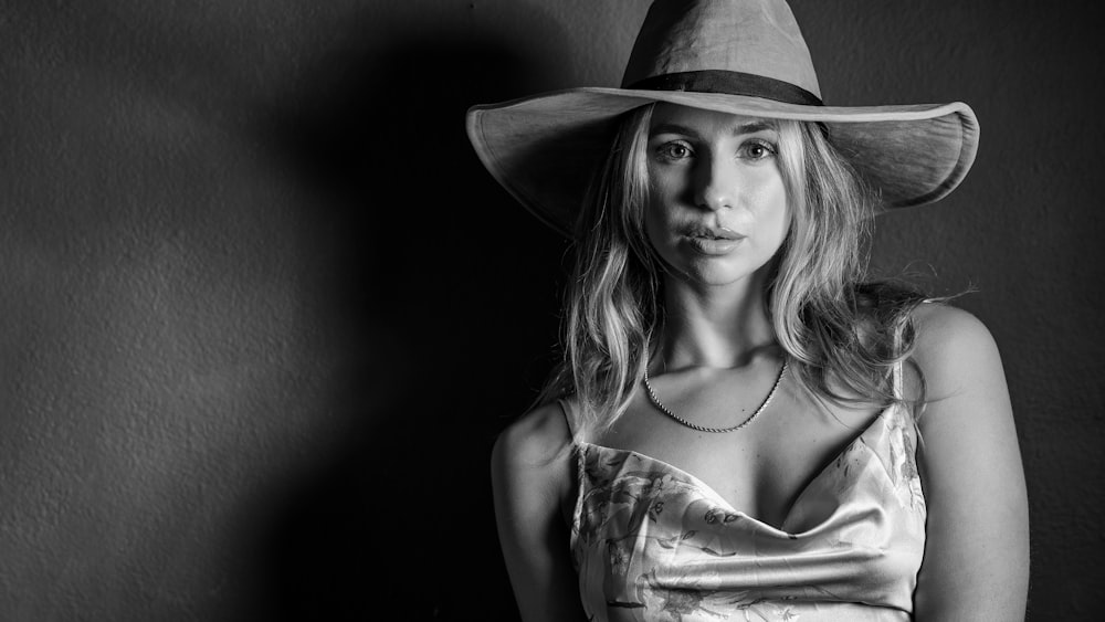 woman in white spaghetti strap top wearing brown hat