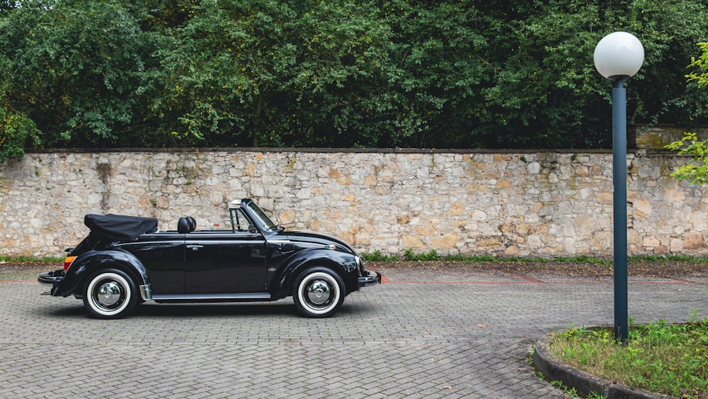 black convertible parked on gray concrete pavement