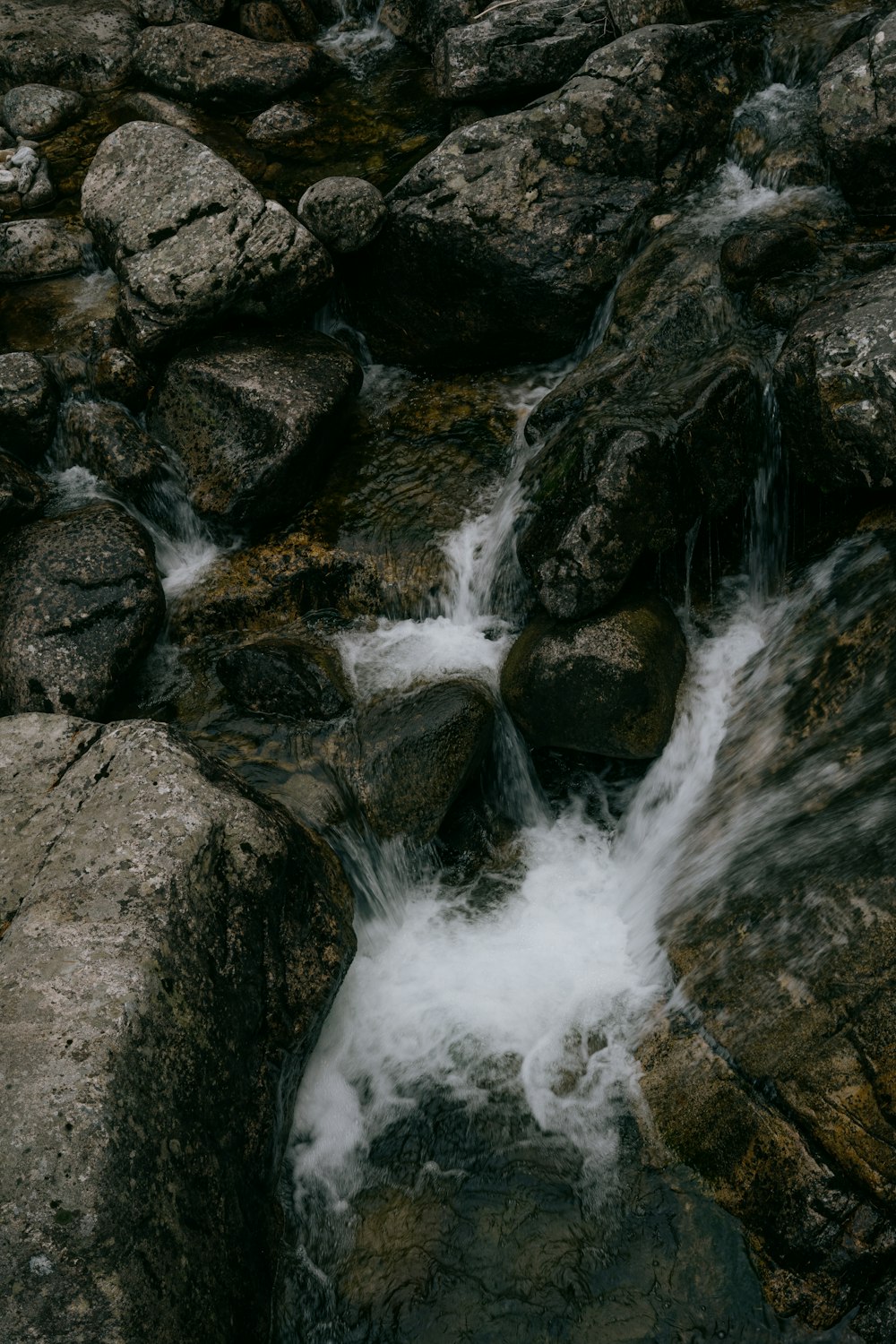 water falls on rocky shore during daytime