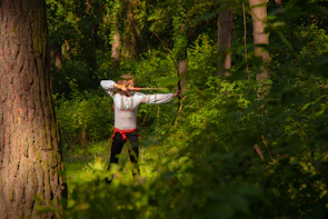 Visitors engaging in archery class surrounded by lush green forest in Sentul Eco Edu Tourism Forest