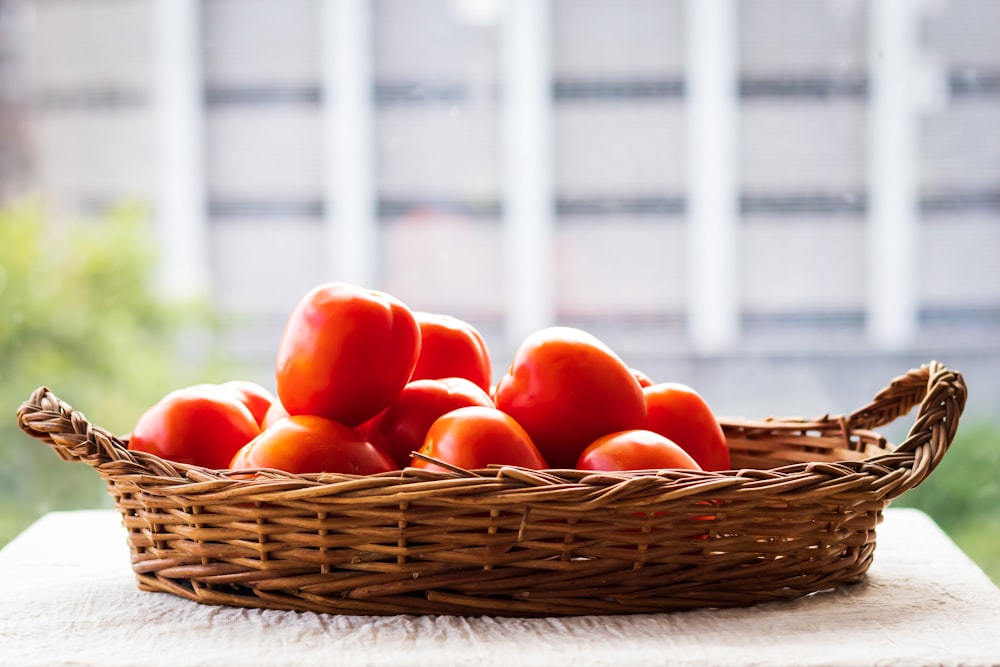 pomodori rossi su cesto intrecciato marrone