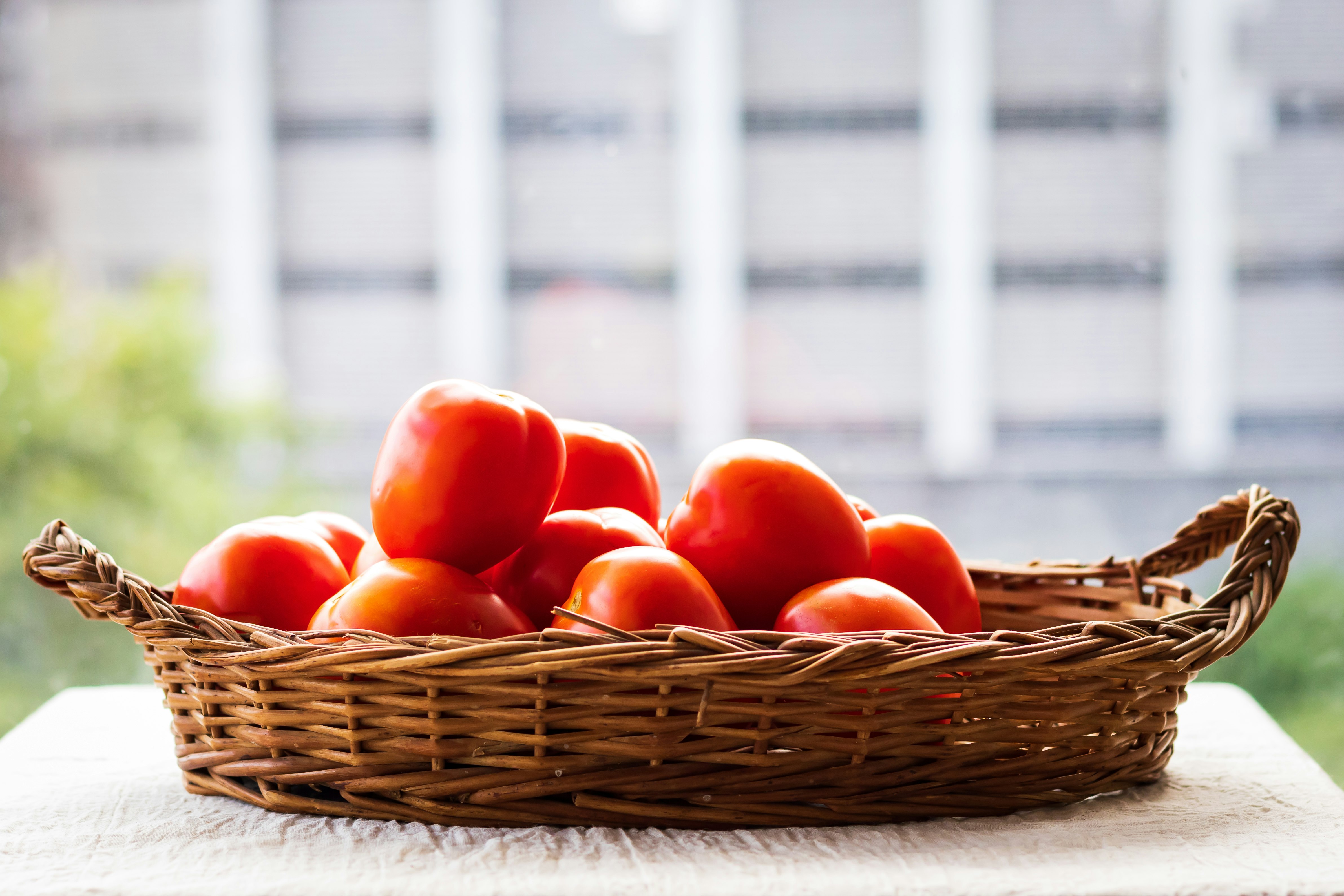 red tomatoes on brown woven basket