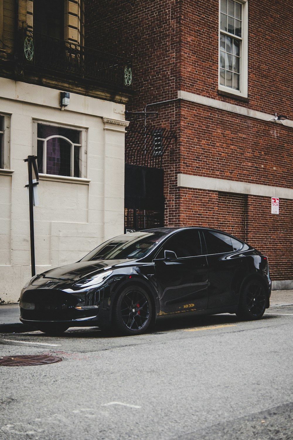 black porsche 911 parked beside brown brick building