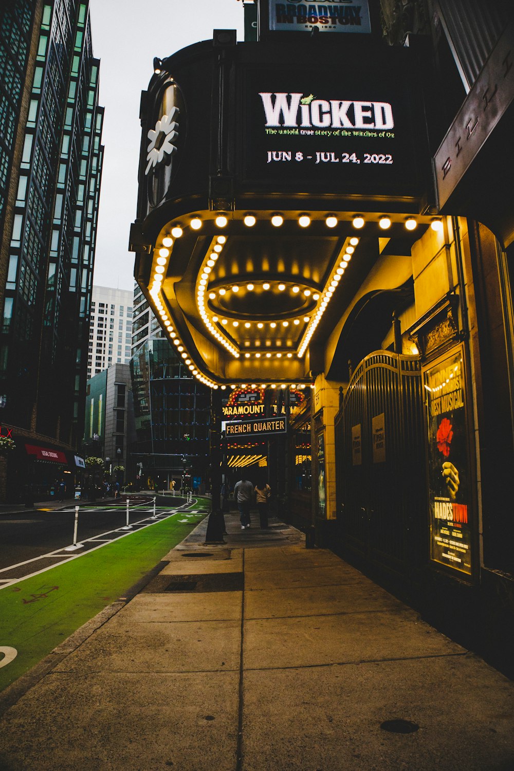 people walking on sidewalk near building during night time