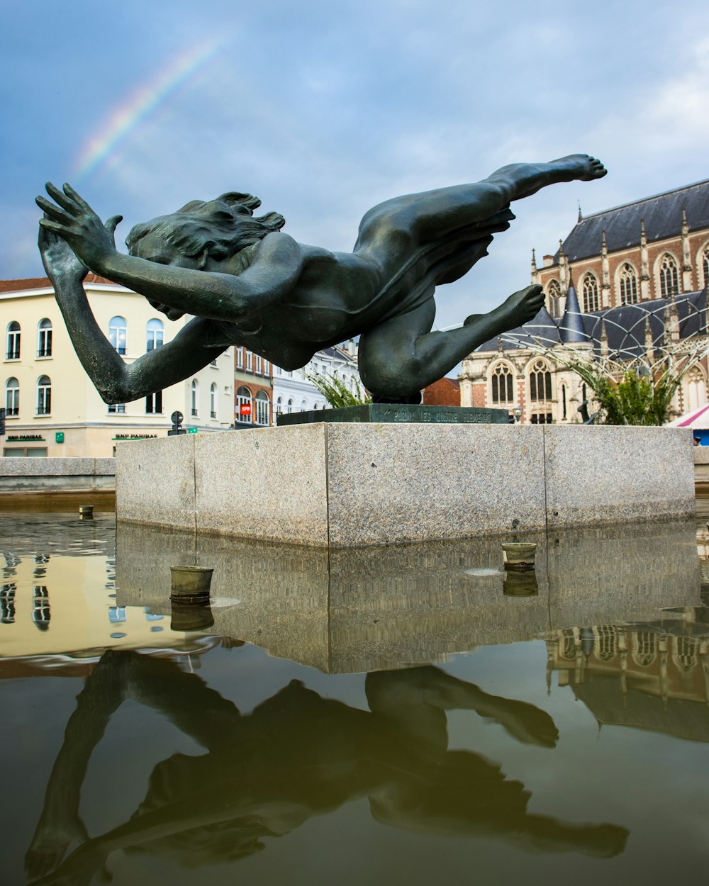 black statue of man on water fountain