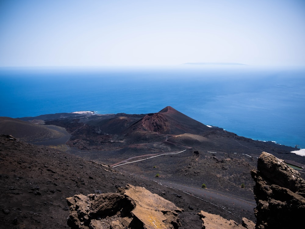 aerial view of green and brown mountain under blue sky during daytime