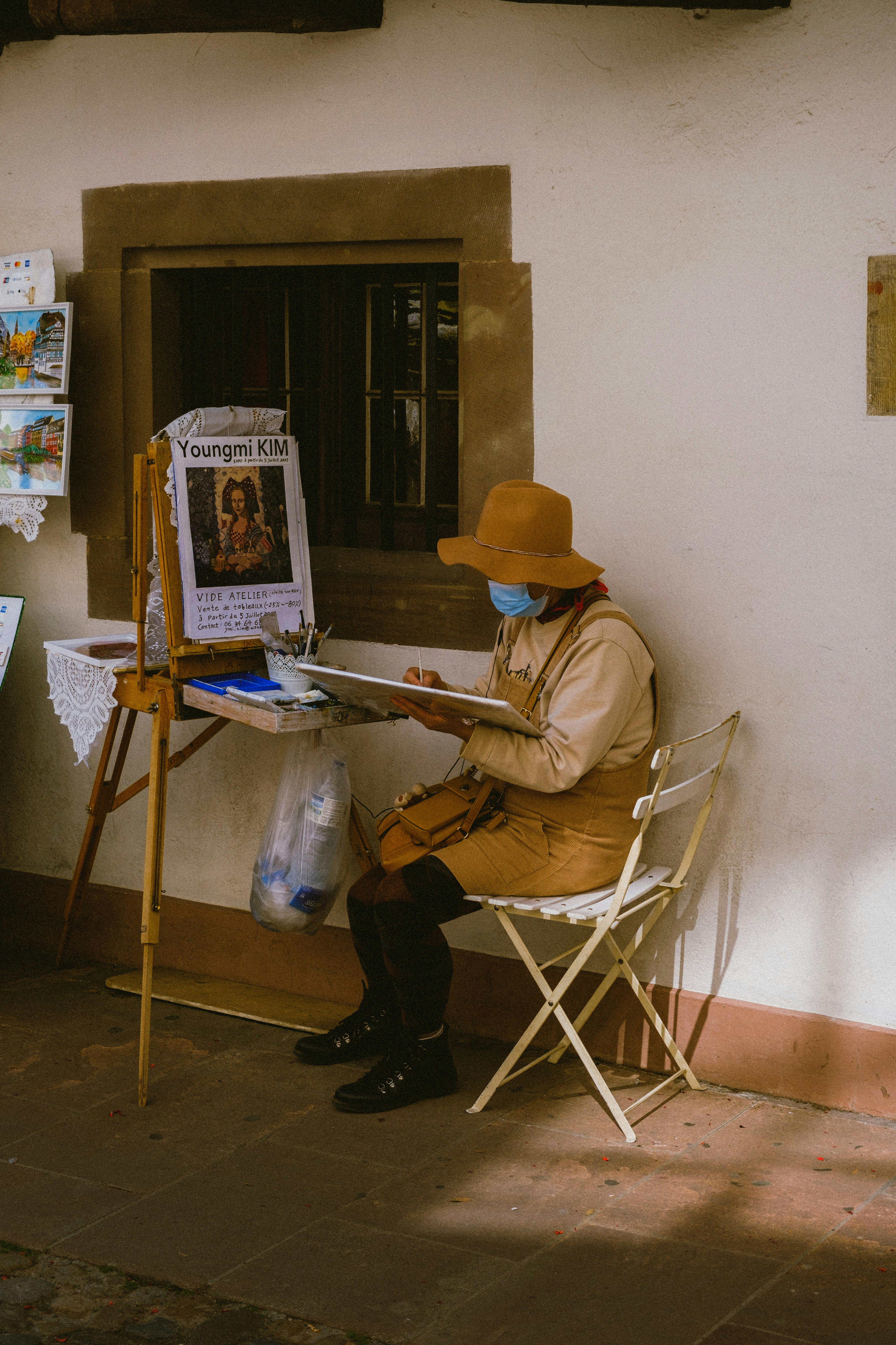 man in brown jacket sitting on folding chair
