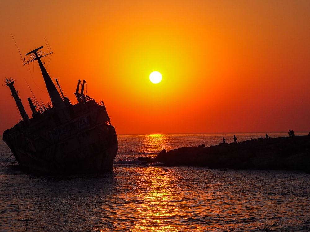 brown ship on sea during sunset