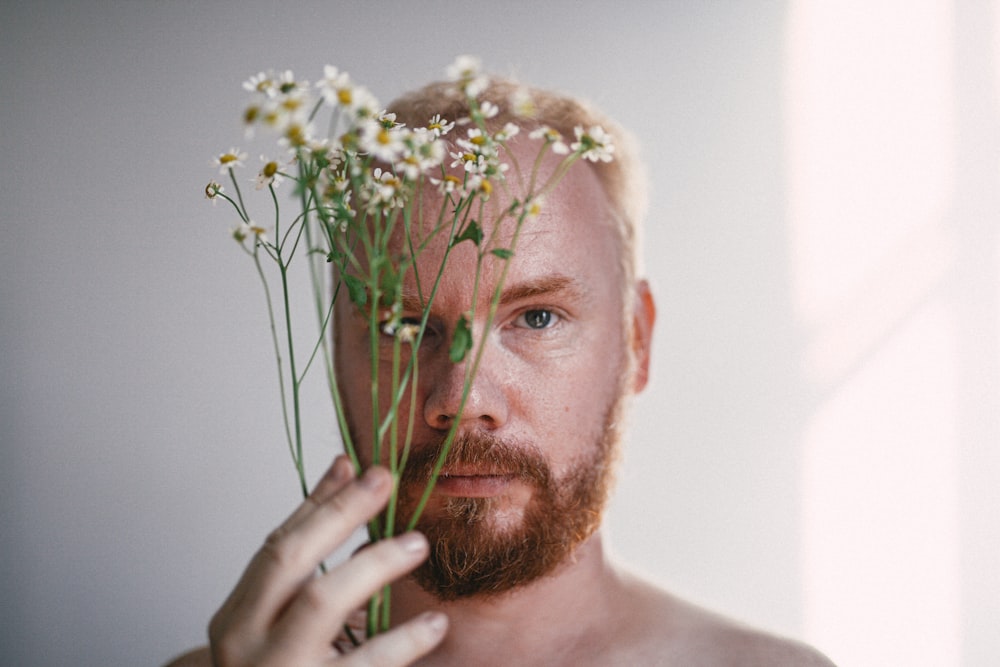 man holding white and green flower bouquet