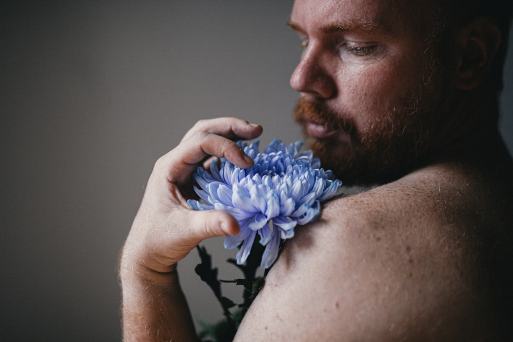 Mann in schwarz-weißem Blumenhemd mit blauer Blume